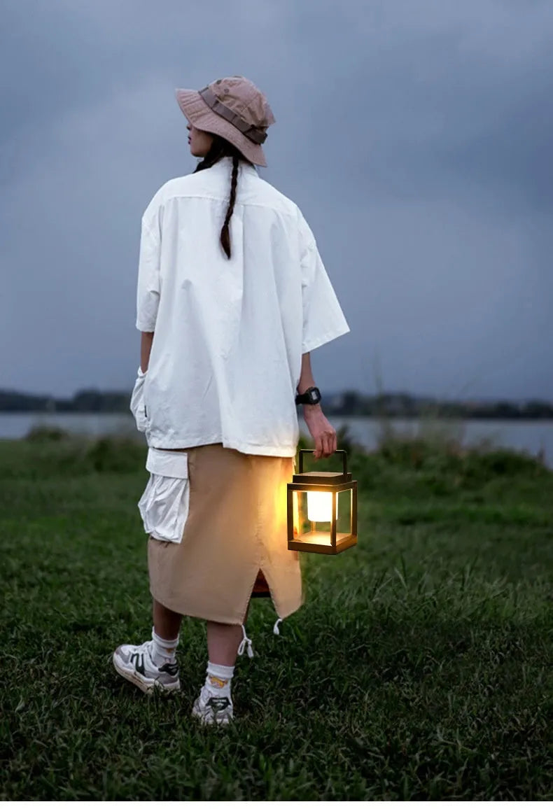 Outdoor USB handheld multifunctional charging ambient light lantern with black cover and white shell