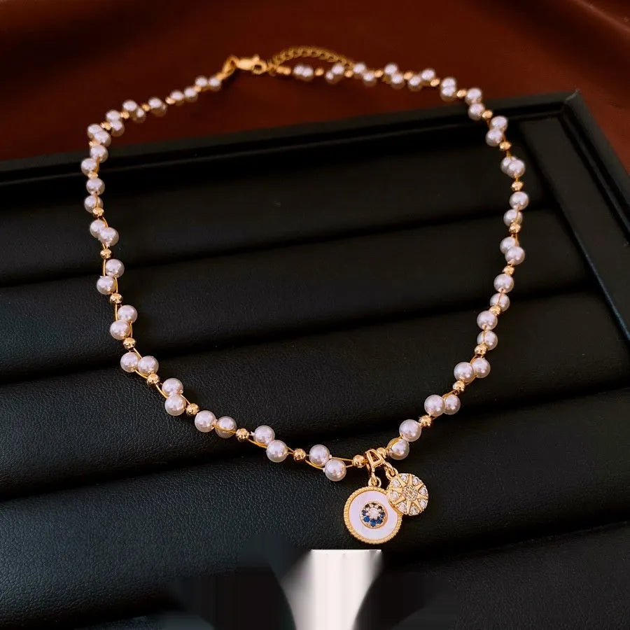 Gold electroplated round pendant necklace with zircon accents on clavicle chain