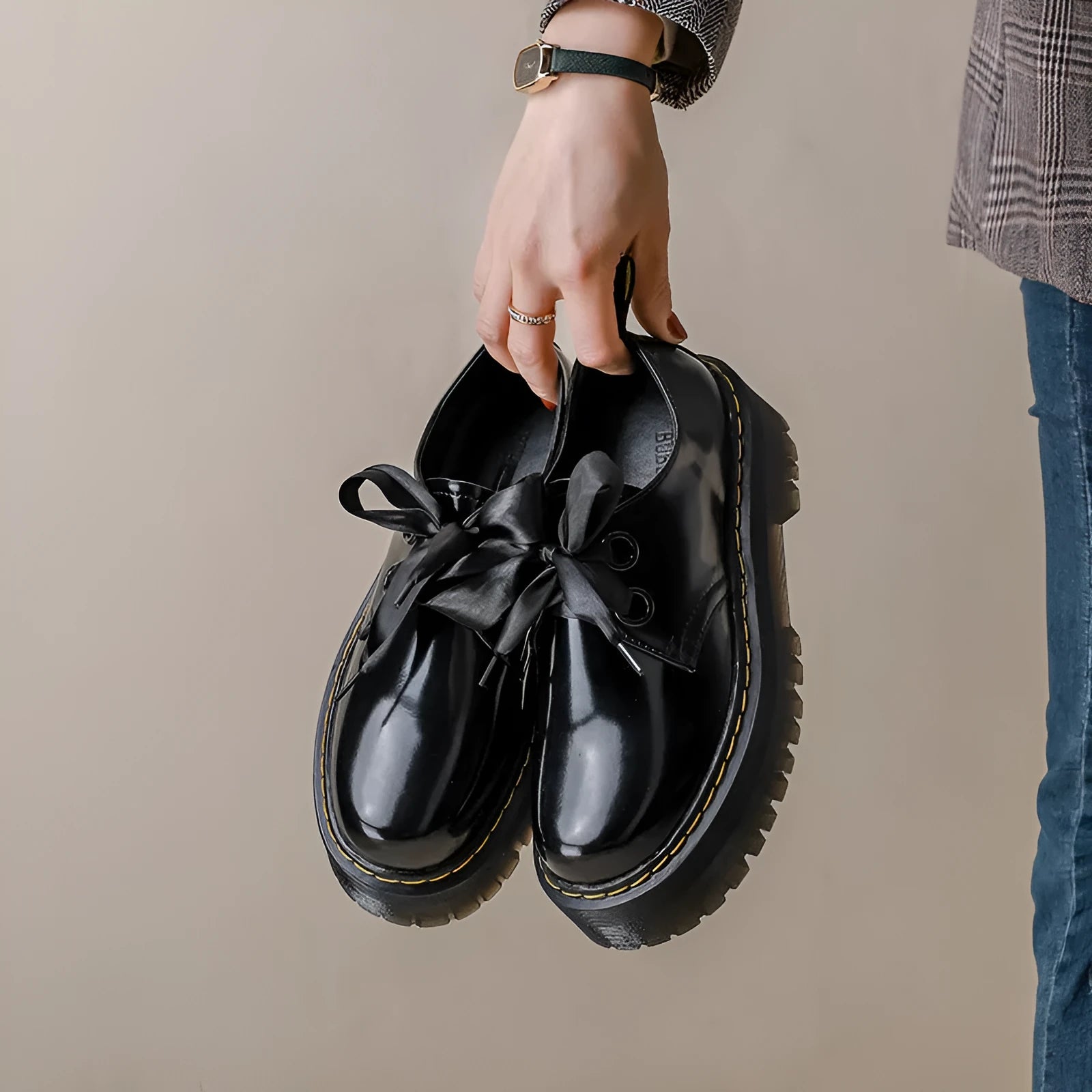 White and black women's thick soled shoes with ribbon and cross straps and laced closure.