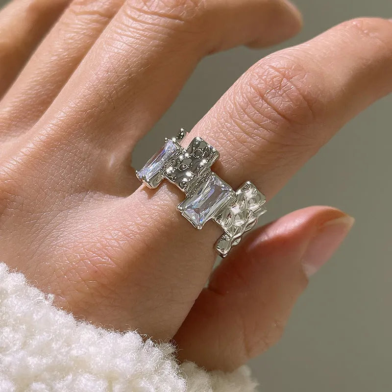 Silver plated open ring with cross design and zircon crystals.