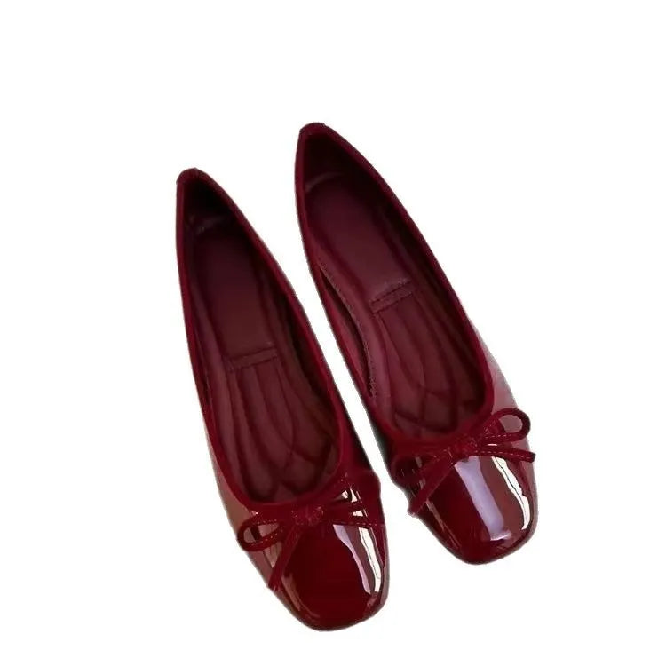 Pair of black patent leather Mary Jane flats with low heel and round toe