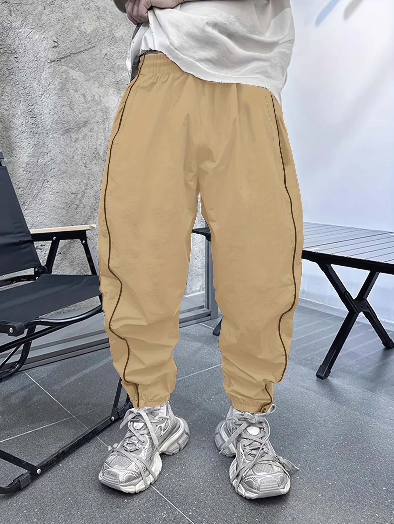 Man wearing loose grey cropped bamboo fibre sports pants in a casual setting.