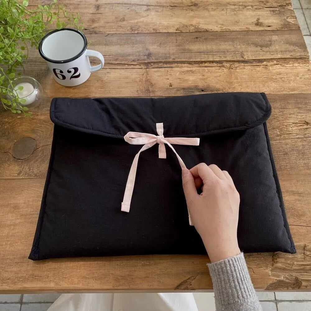 Black and white striped quilted laptop bag with a ballet-style bow.