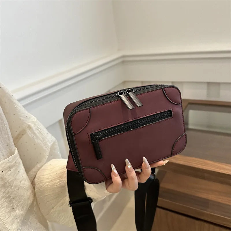 Small square black women's crossbody bag with single strap and external pockets