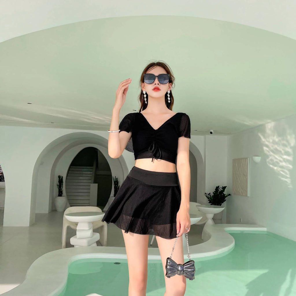 Women's solid colour two-piece swimsuit with a skirted bottom in white, black, or pink.