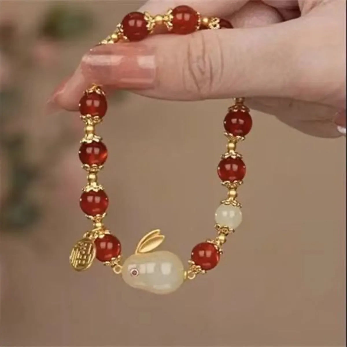 A glass and coloured glaze bracelet with a rabbit motif and a peace buckle clasp.