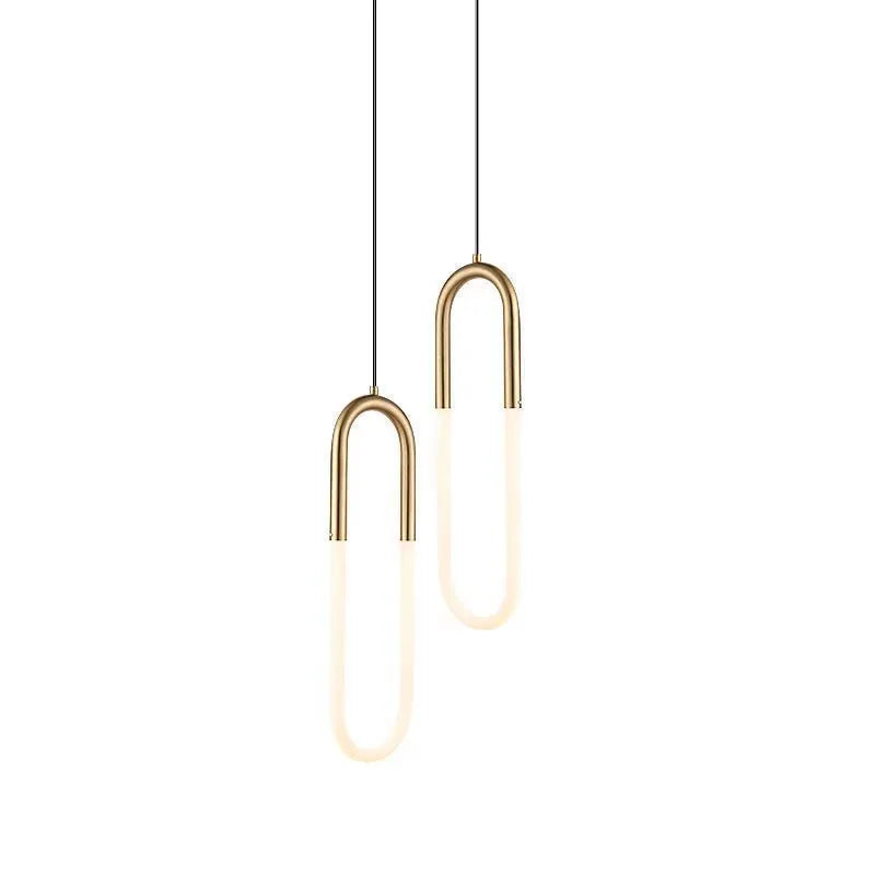 Minimalist black U-shaped pendant light with a downward-facing bulb mounted next to a bed.