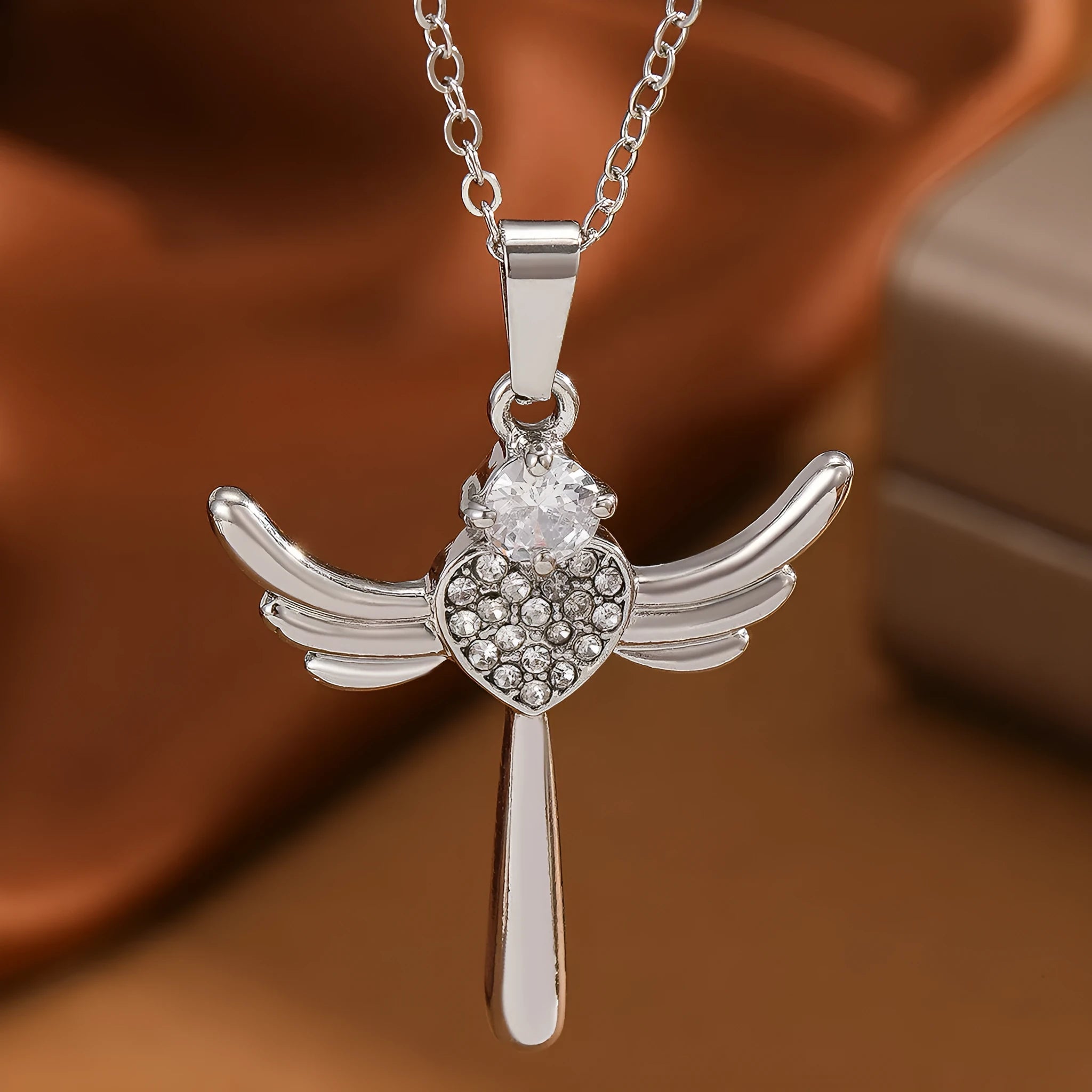 Silver heart-shaped angel wings pendant clavicle chain necklace with cross elements on display