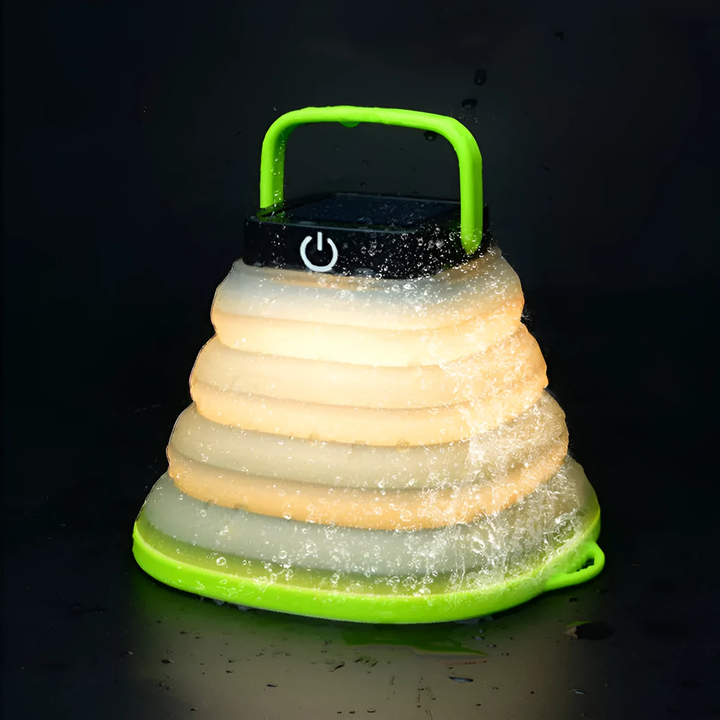 Green telescopic LED camping light folded and extended on a table with suction cup