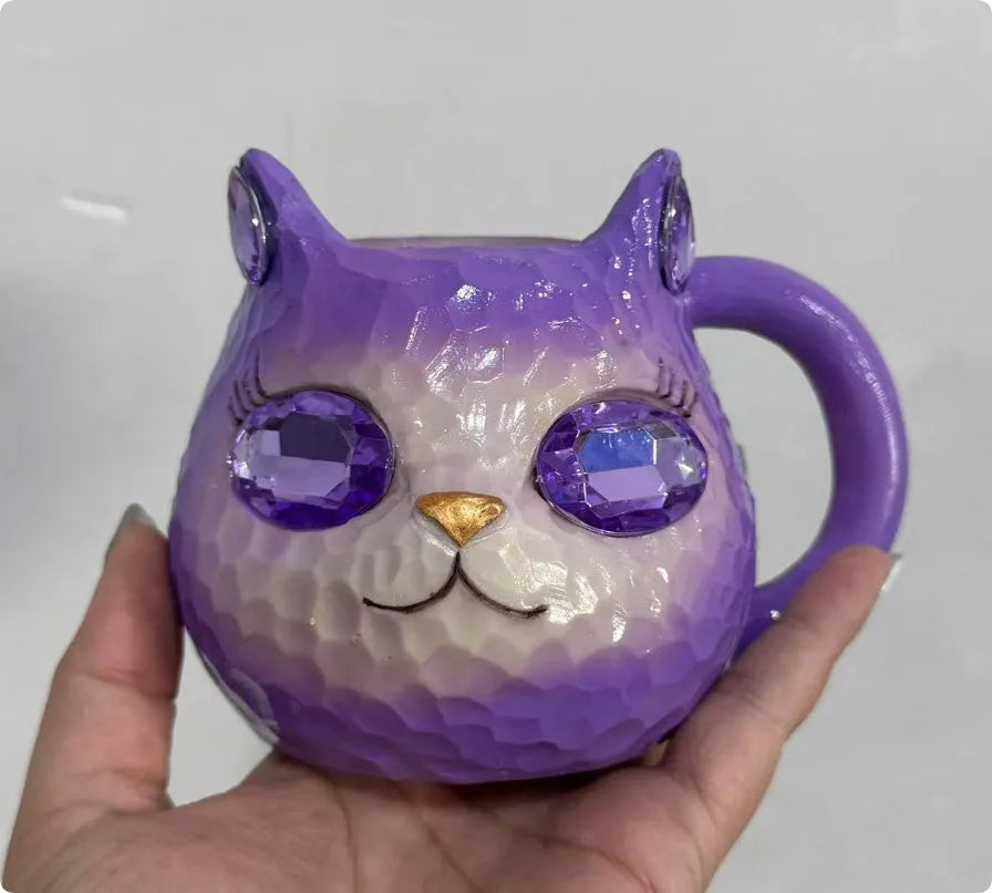 Small solid-colour resin cat cup craft figurine on a table, shown in purple, green, blue, and pink colour variants.