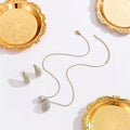 Elliptical necklace and earring set with full diamond droplet shape, silver-tone finish