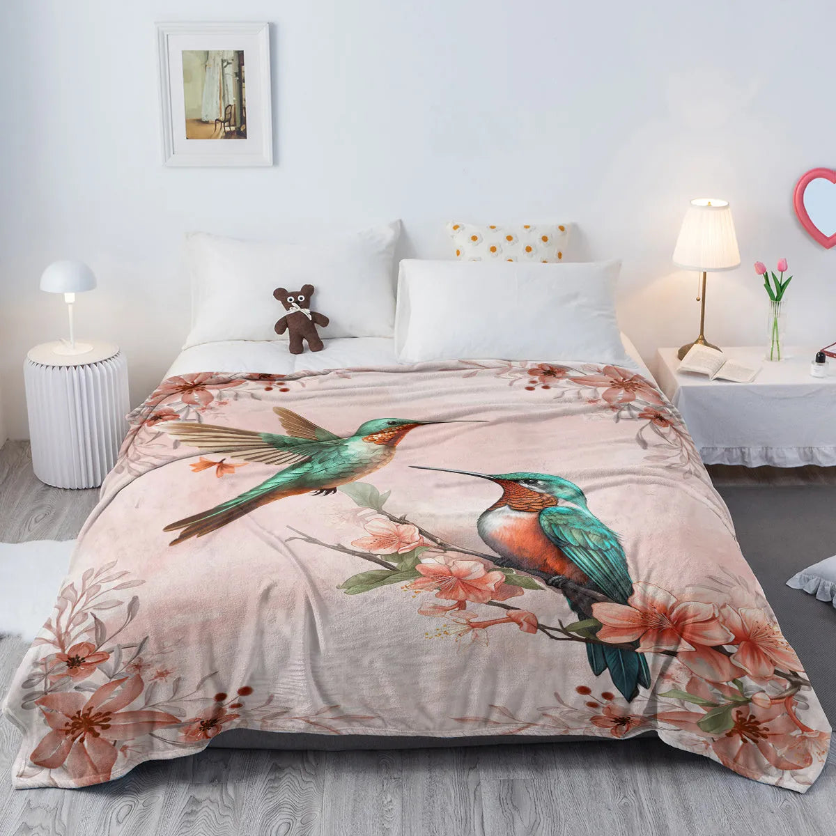 Pink hummingbird floral fleece throw blanket on sofa with floral print