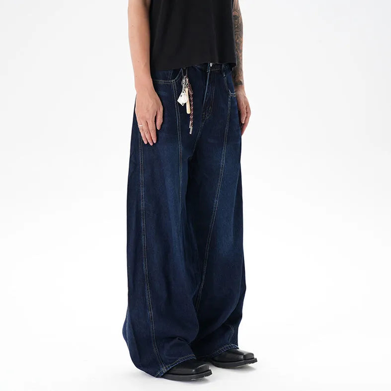 Dark blue washed distressed denim wide leg machete jeans laid flat, showing the wide leg cut and textured finish.