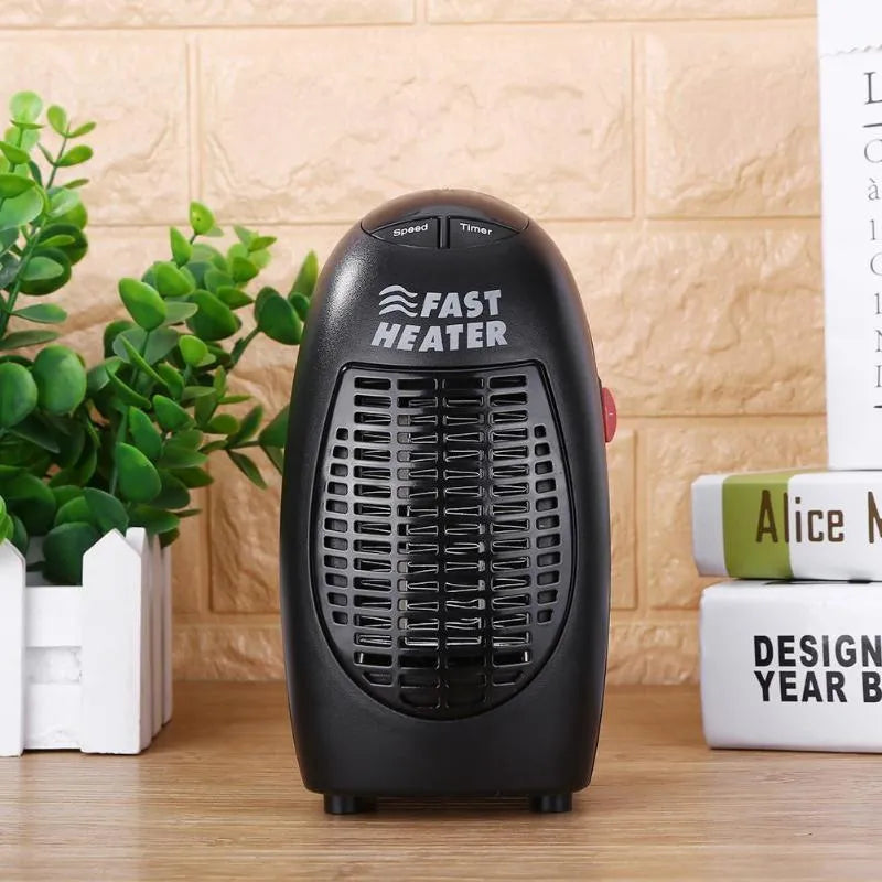 Black mini electric heater with digital display and a rotating three-prong plug on a desk.