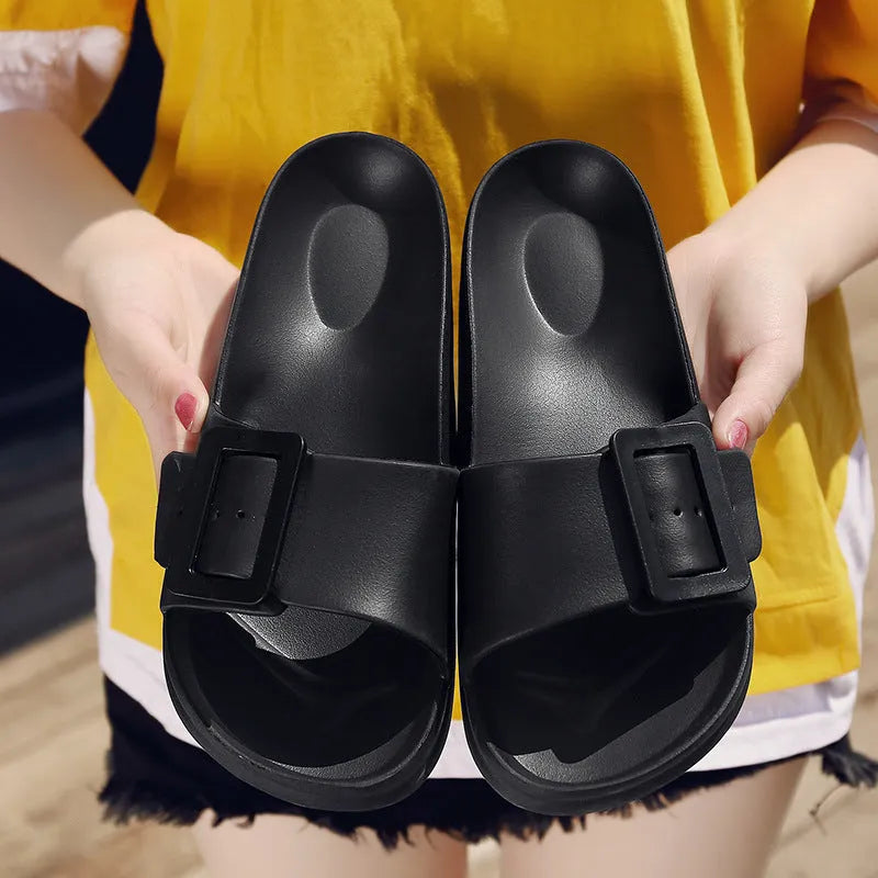 A pair of women's grey blue buckle slipper sandals with an adjustable strap on a soft EVA sole.