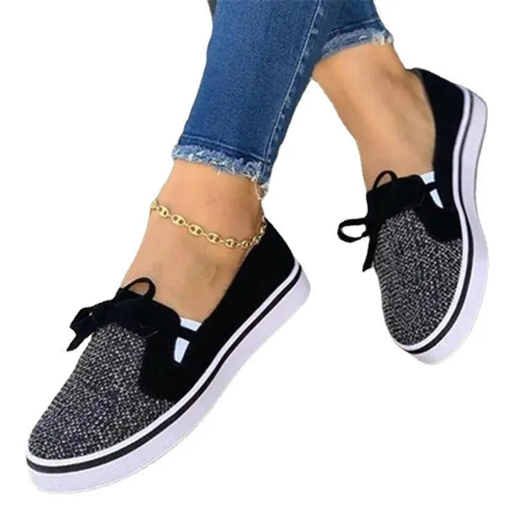 Women's low top flat shoes with cloth upper and shallow mouth cut, shown in white, red, blue, and black