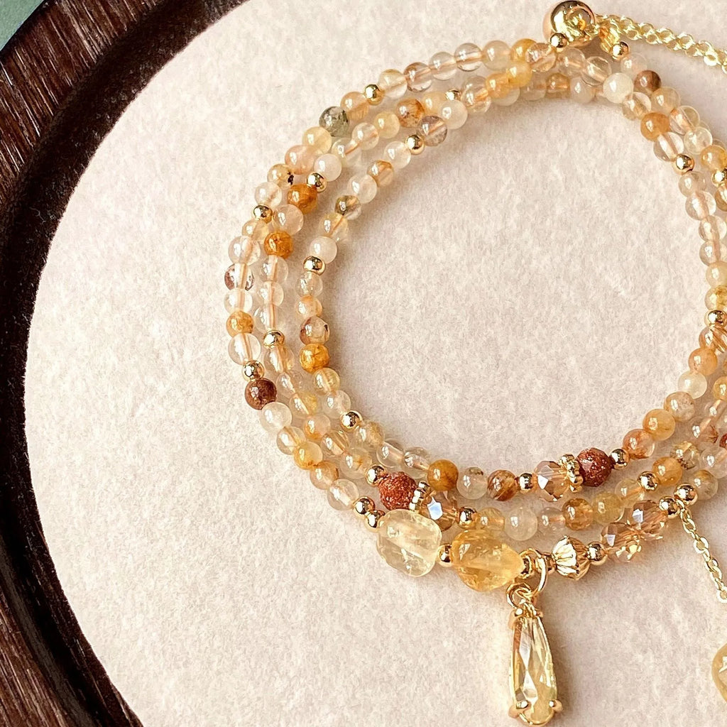 Gold electroplated women's bracelet with three interlinked circles made from natural caramel-coloured citrine and a Saturn decoration.