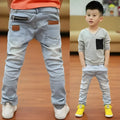 Boys' striped denim harem trousers with an elasticated waistband on a hanger.