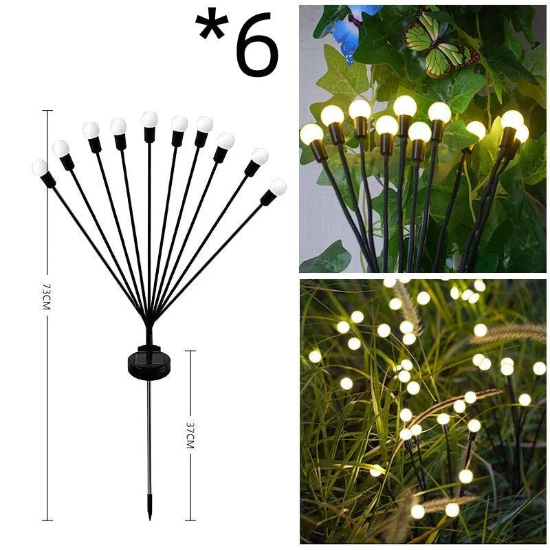 Solar-powered LED garden ground light with stainless steel spike, lit up in a lawn at dusk.