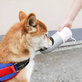 Moestar rocket-shaped pet drinking cup in white with grey or orange accents showing one-button lock mechanism