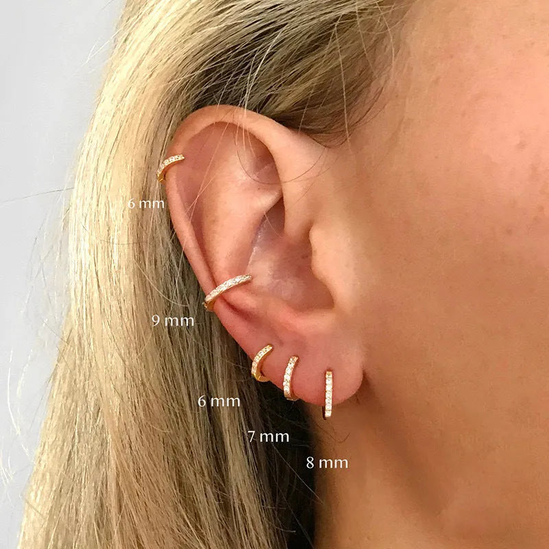 Circle-shaped perforated stud earrings in gold, rose gold, and silver colours on a white background.