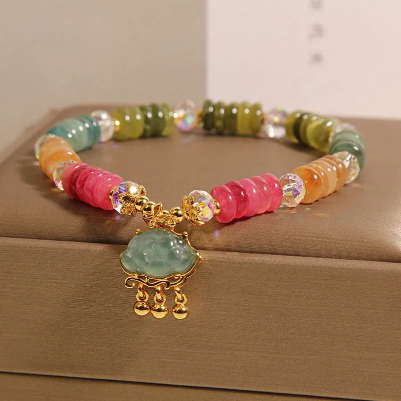 Colorful Tourmaline Jade Xiangyun crystal bracelet with alloy inlay and stone accents on display