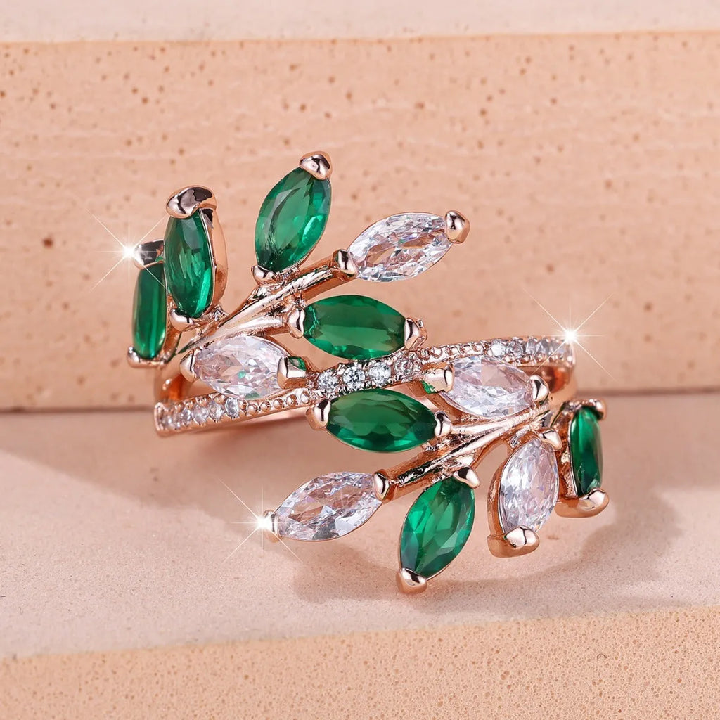 Adjustable copper leaf fashion ring with a blue zircon stone on a model's hand.