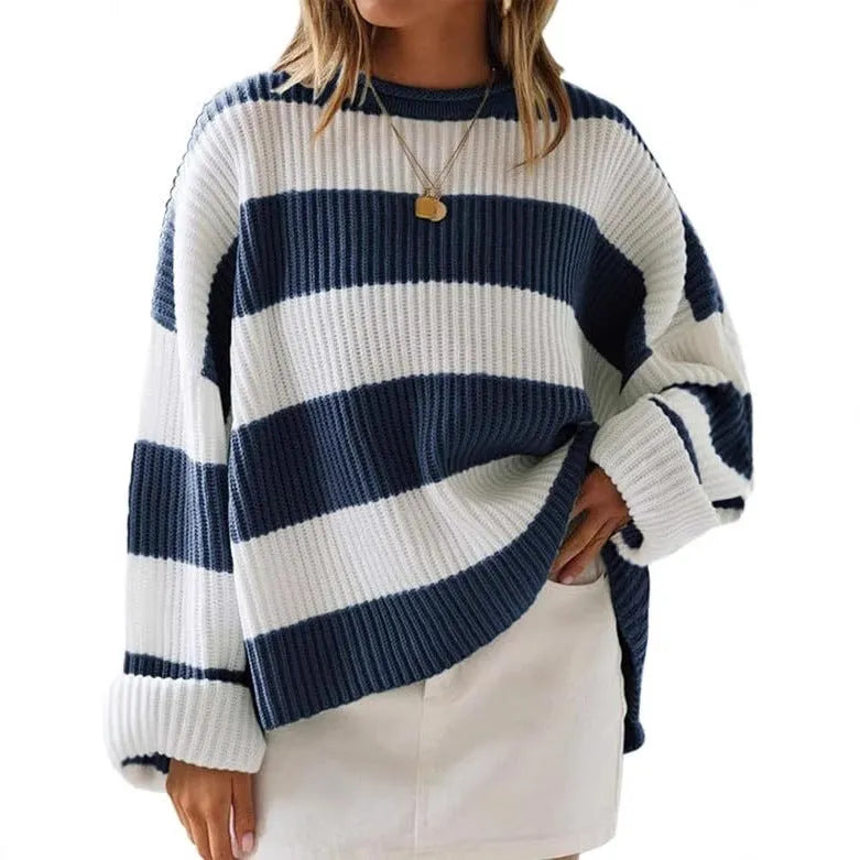 Woman wearing a loose striped sweater with long bell sleeves and white crocheted flower details on the front.