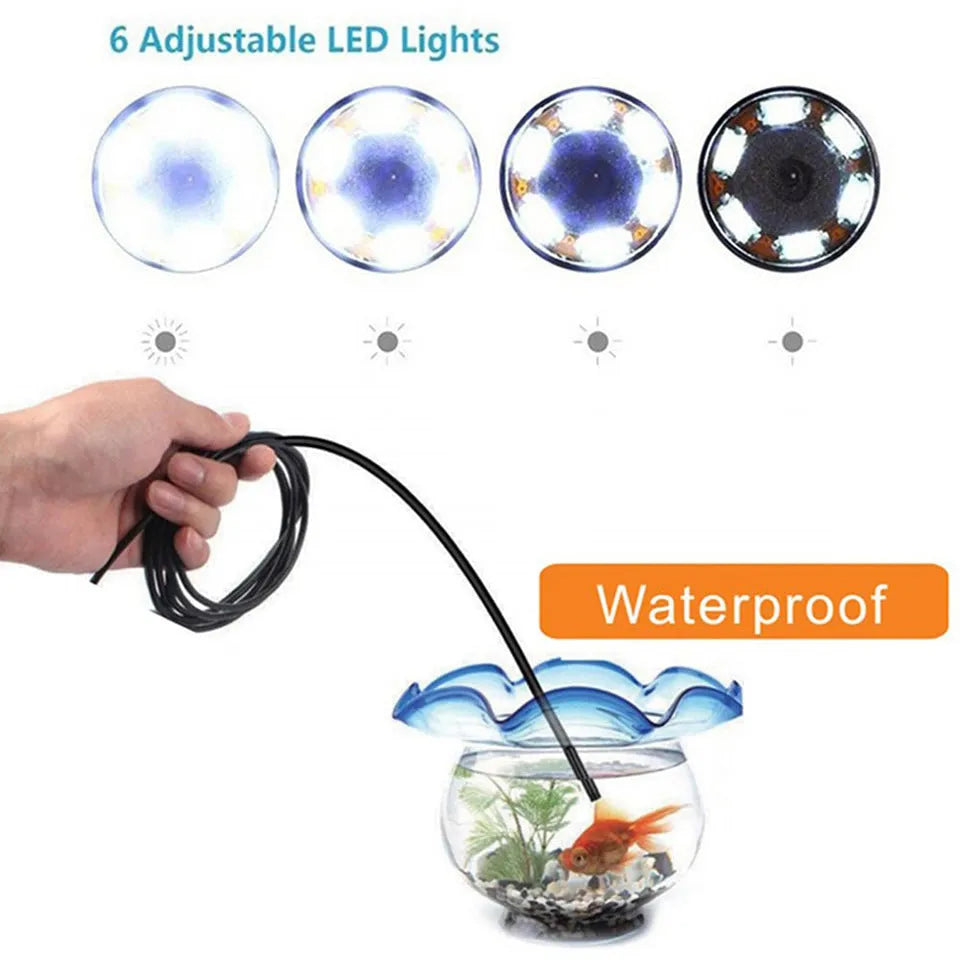 Android phone connected to a flexible endoscope camera with hook, magnet, and mirror attachments on a table.