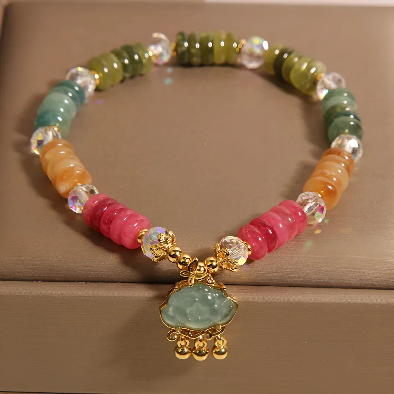 Colorful Tourmaline Jade Xiangyun crystal bracelet with alloy inlay and stone accents on display