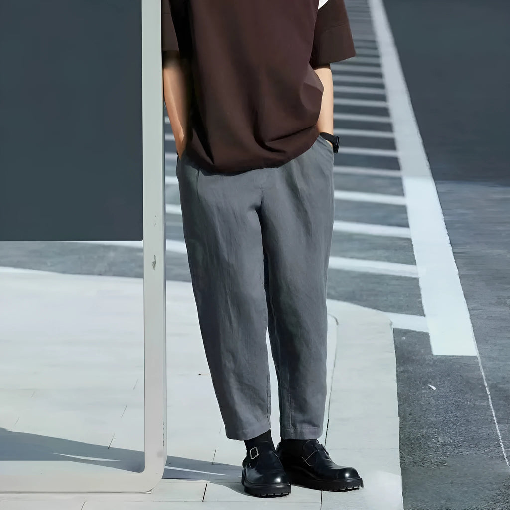Man wearing beige loose-fit straight leg casual trousers with a drawstring waistband.