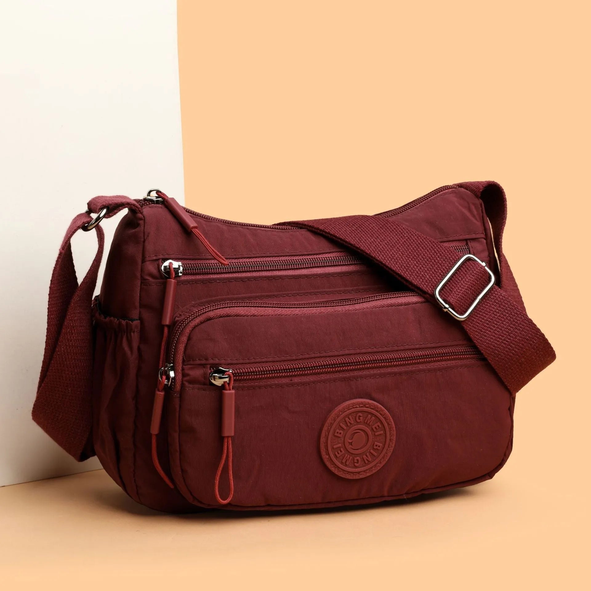 Soft water-repellent nylon crossbody bag in black with an outer pocket and zipped main compartment.