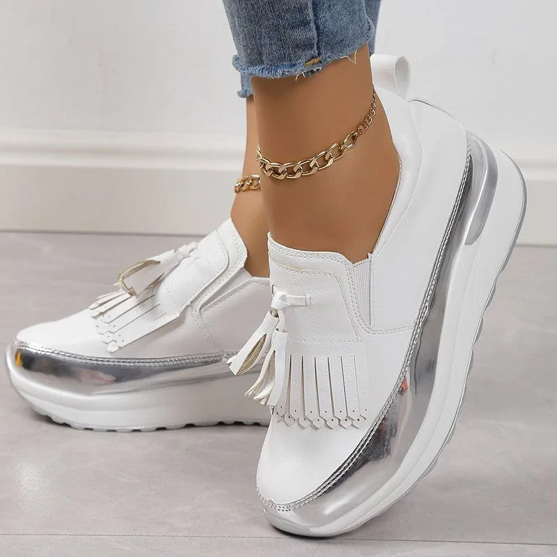 Women's black casual platform shoes with tassel detail and muffin wedge heel on a white background