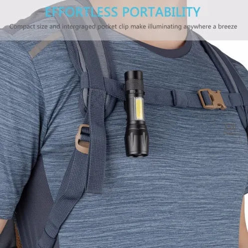 Small black aluminium telescopic LED flashlight with zoom adjustment and a pocket clip.