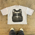 Person wearing a printed cotton short-sleeve pullover with a drop-shoulder design and retro graphic in a street hipster style.