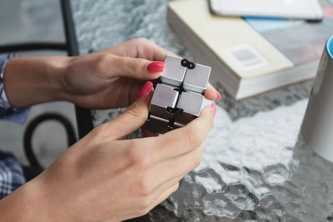 Zinc alloy infinity cube fidget toy showing black and silver colour options, sized at 4cm.