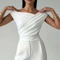 Color-blocked women's top with asymmetric shoulder and ruffled hem, slim fit, black with white panels, polyester fabric.