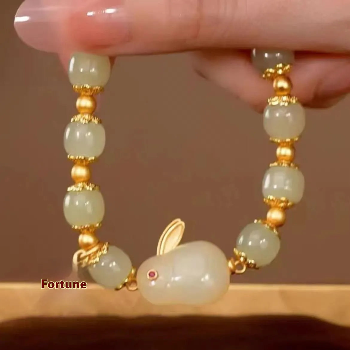 Green electroplated jade hare bracelet for women with Chinese style and lily design elements.