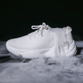 Women's white fly-knit sports shoes with thick rubber sole and front strap.