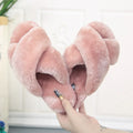 Women's black cross open-toe fur slippers with a textured sole on a light background.
