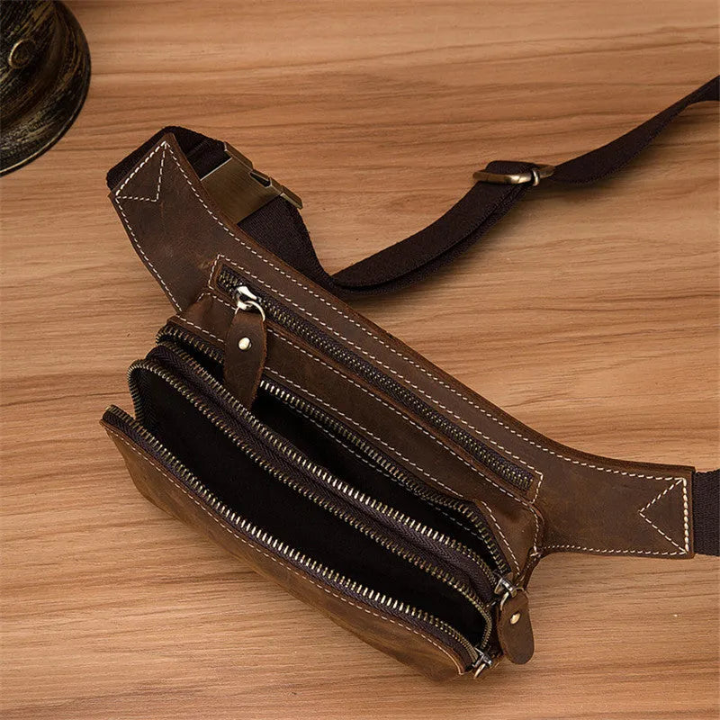 Brown cowhide leather men's waist bag showing pull-closure, worn on hip, with internal phone pouch visible.