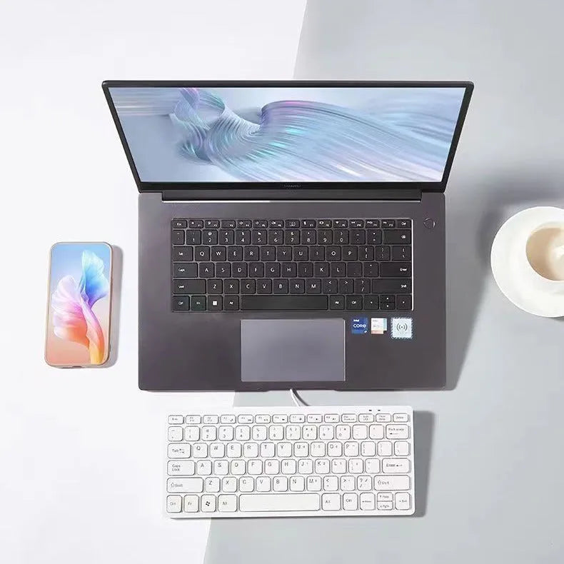 USB wired mini computer keyboard in black, white, pink, or blue colour on a desk.