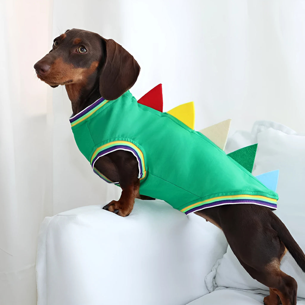 Green cotton dog vest with dinosaur print for small sausage dog, side view, outdoor setting