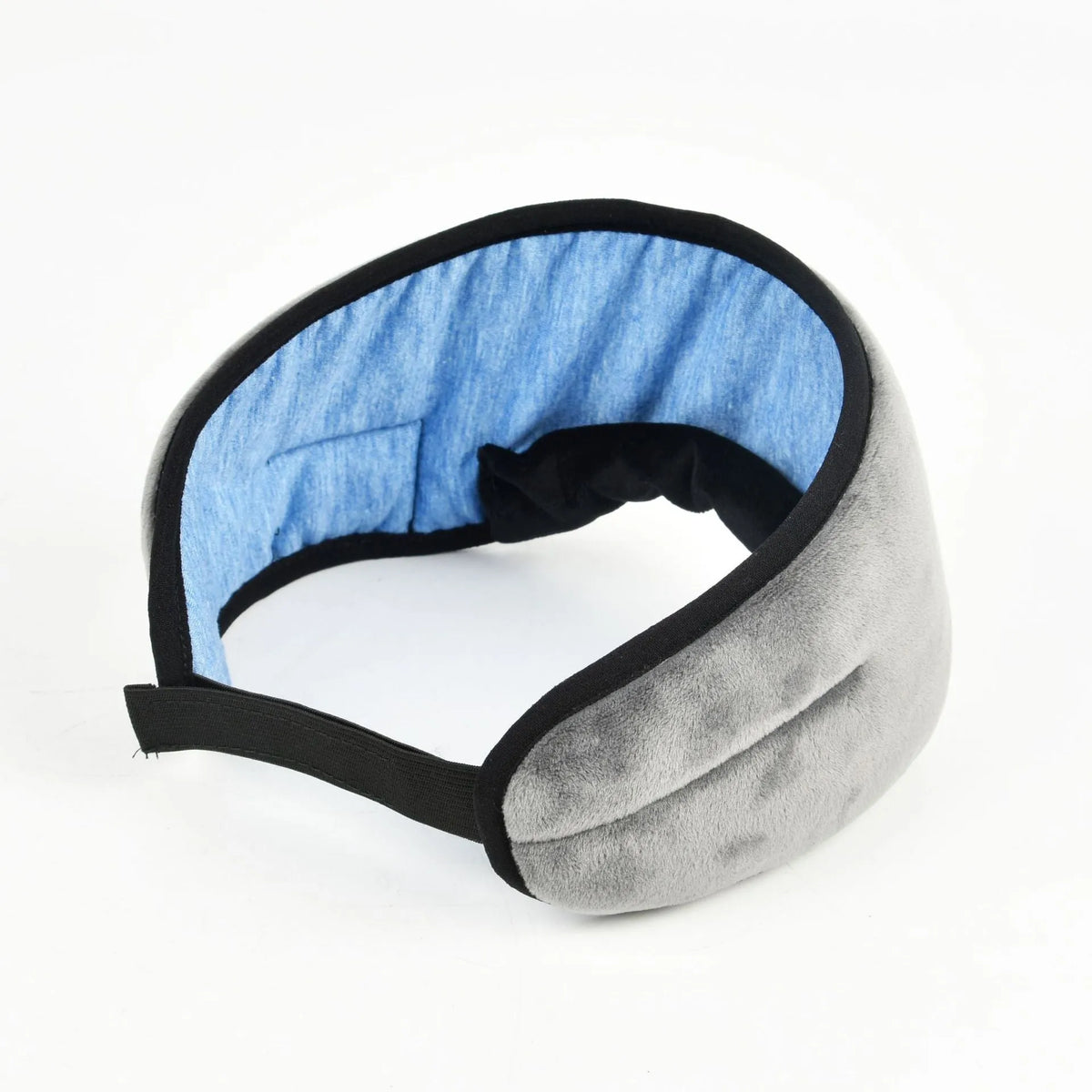 Soft satin sleep eye mask in black with adjustable strap lying flat on a light background
