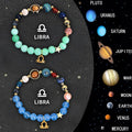 Set of two natural stone beaded bracelets showing zodiac sign designs on a wooden surface.