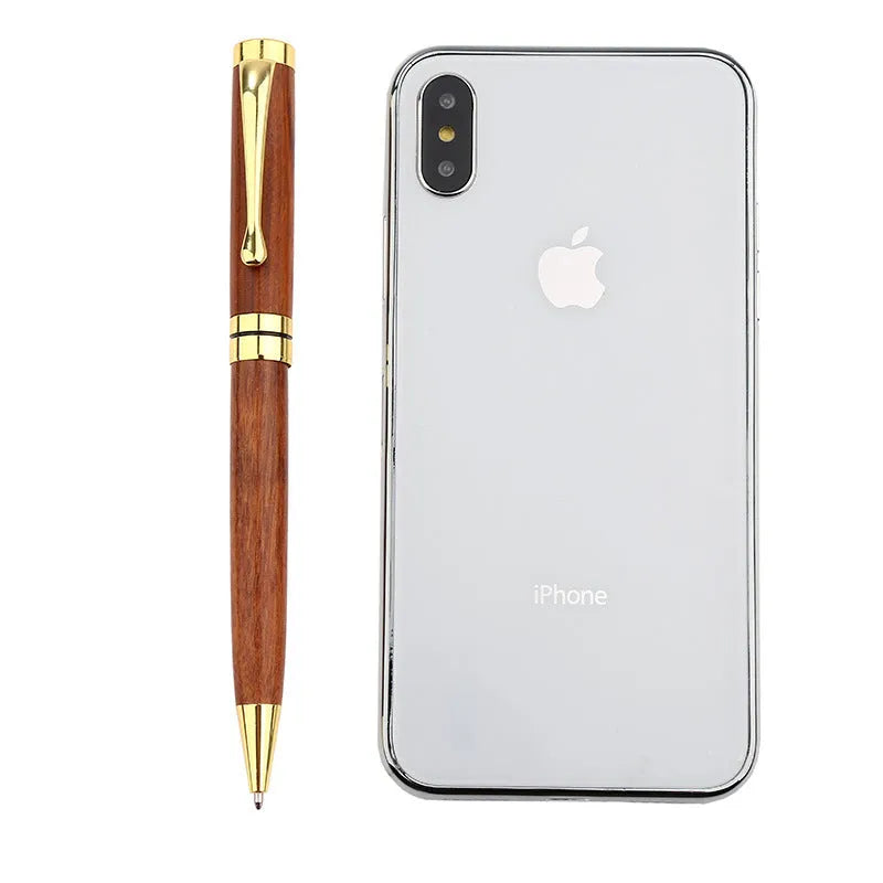 Gold metal and rosewood rollerball pen on a desk, 14cm long