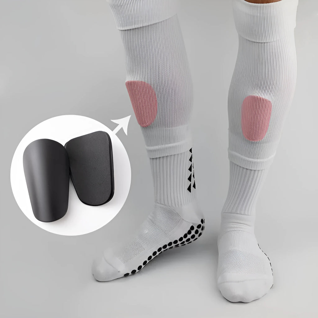 Pair of PU mini shin guards in black, shown on a leg, for football and sports protection.