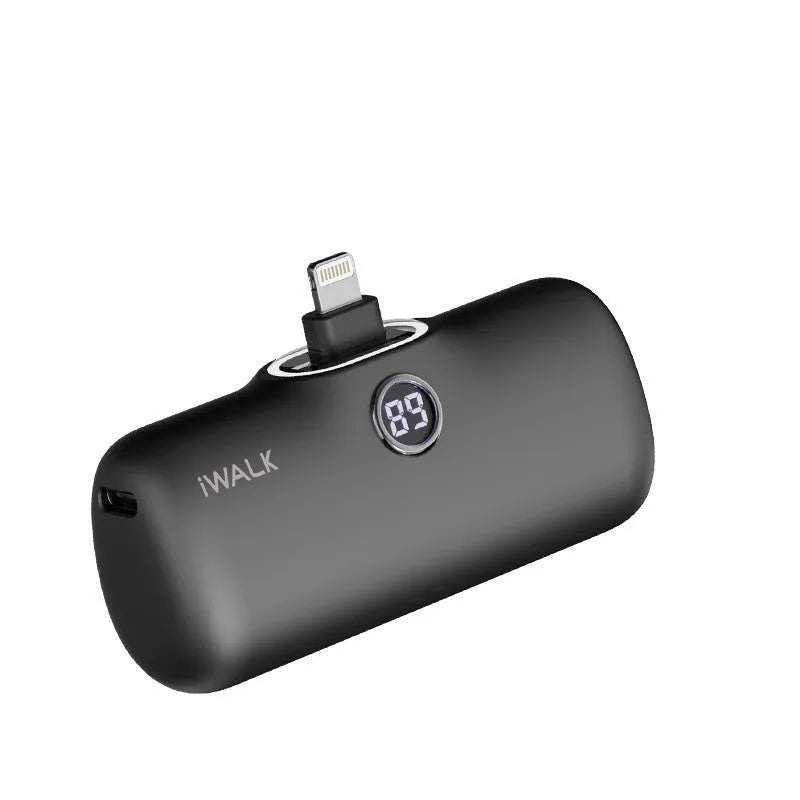 Compact cylindrical white power bank with digital battery percentage screen on a wooden table
