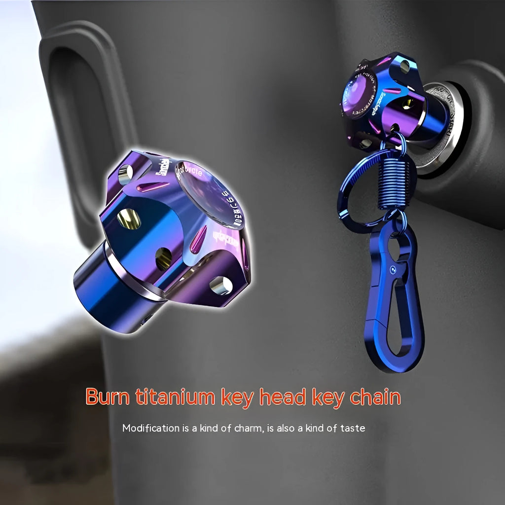 Close-up of a T6 aluminium alloy motorcycle key head cover in a hexagonal design with a blue and white keychain.