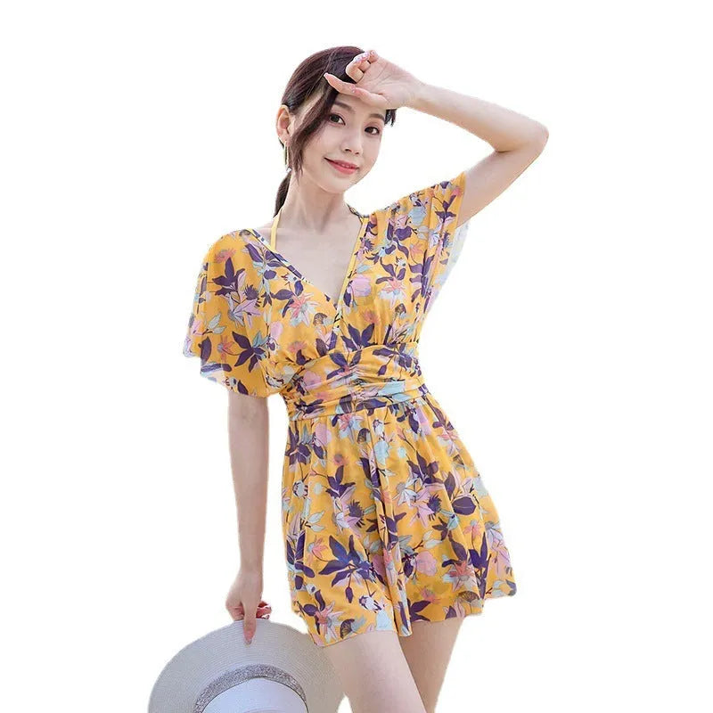 Yellow women's one-piece swimsuit with floral pattern on polyester fabric.